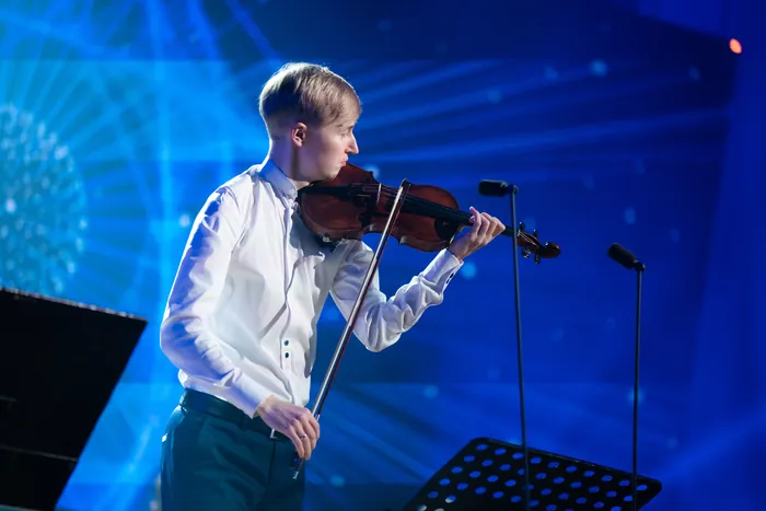 Viiuldaja laval sinises valguses galaõhtu kontsertlavastuses